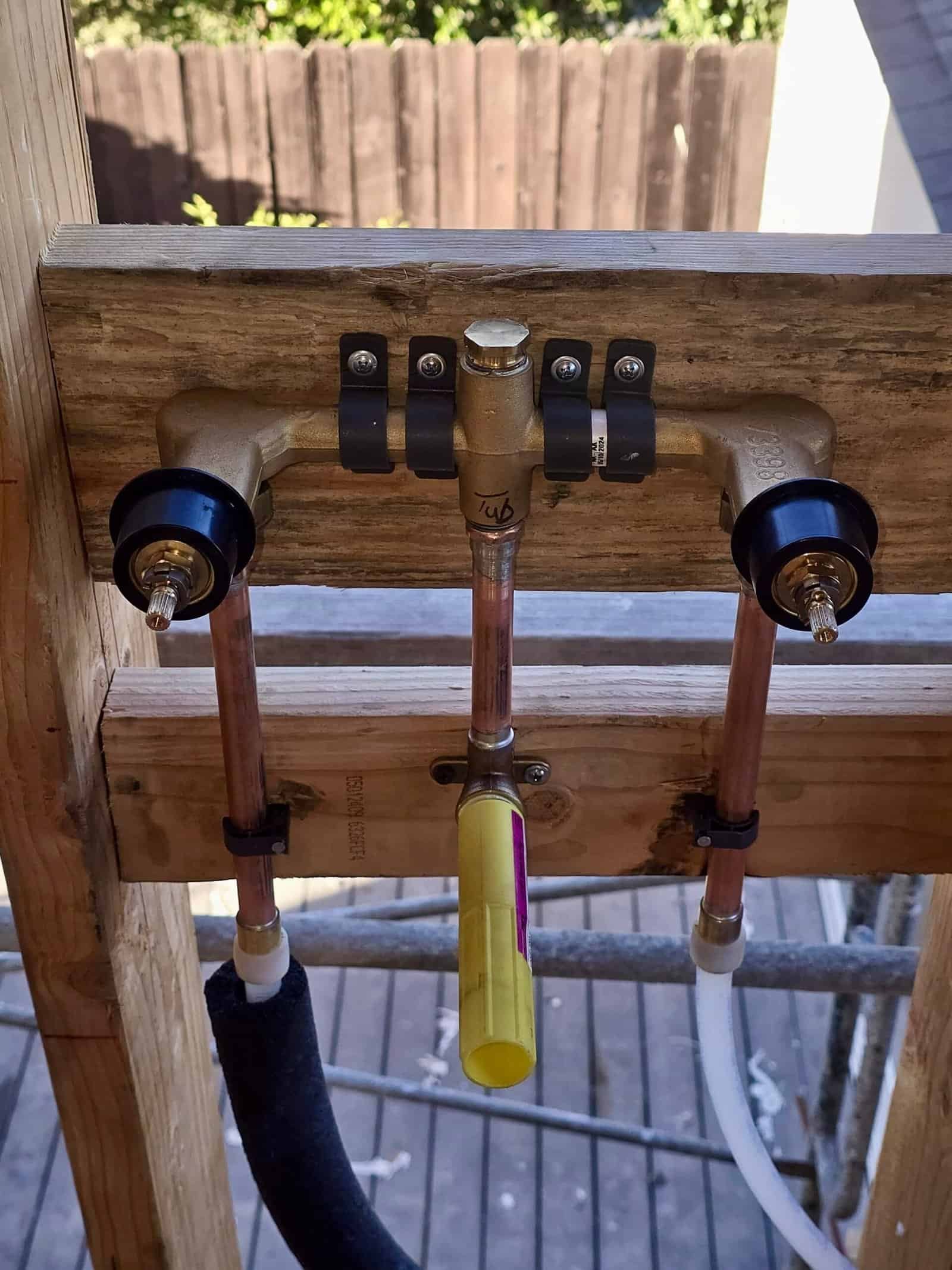 Water supply pipe installation with shut-off valves and copper pipes.