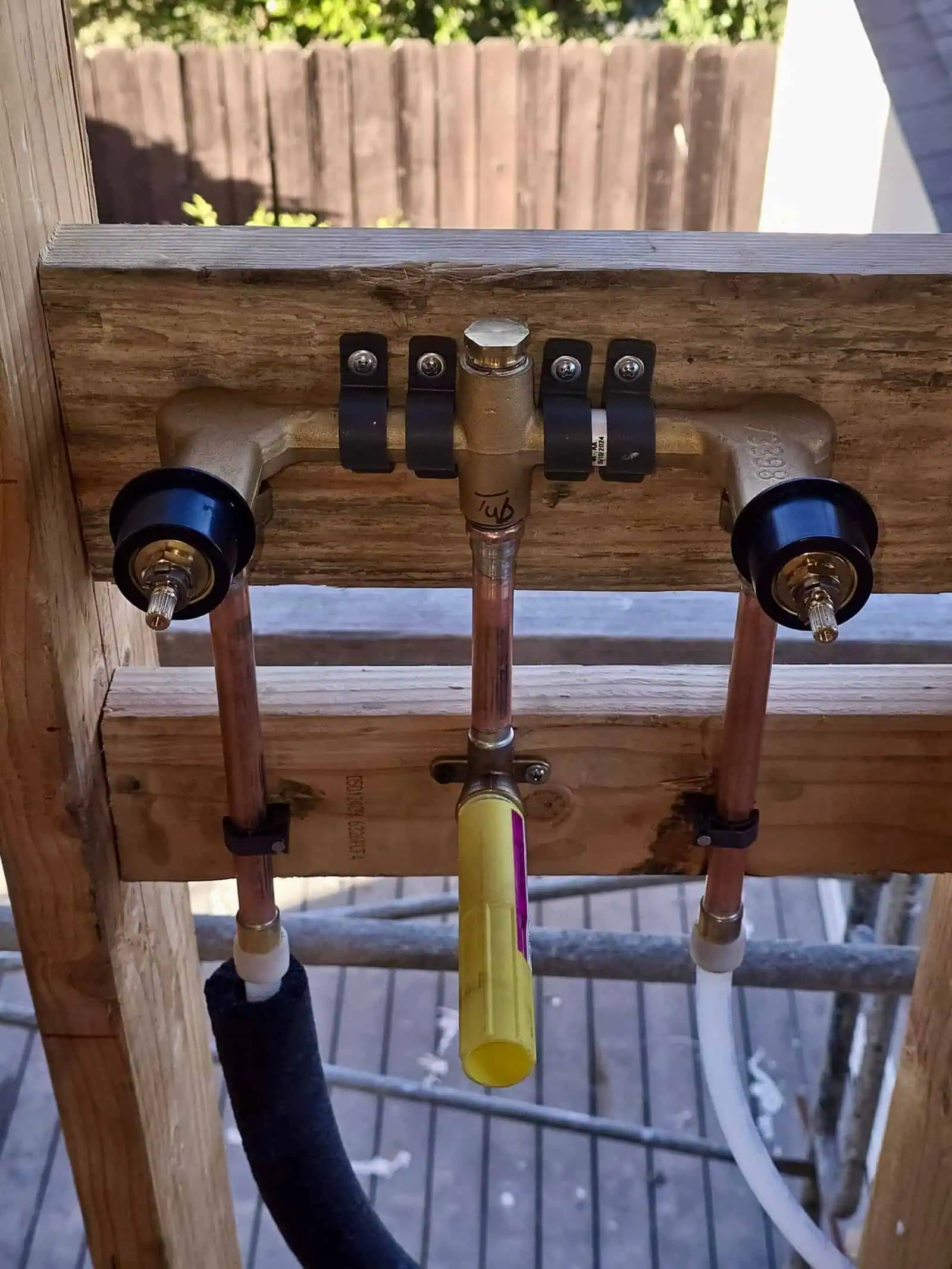 Water supply pipe installation with shut-off valves and copper pipes.