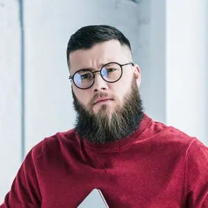 Professional plumber inspecting plumbing system with a serious expression.