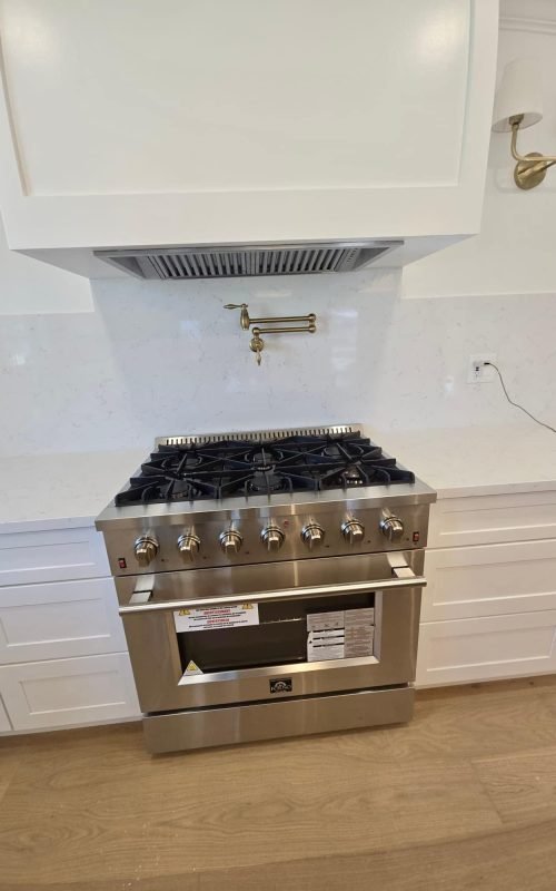 Stainless steel gas stove with oven in modern kitchen.
